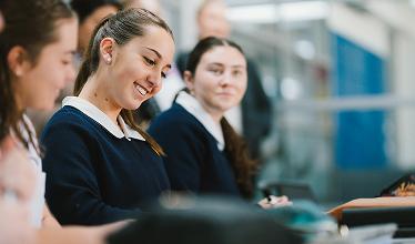 Two students in a class smiling