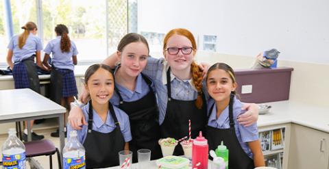 A group of students sitting at a desk in a classroom