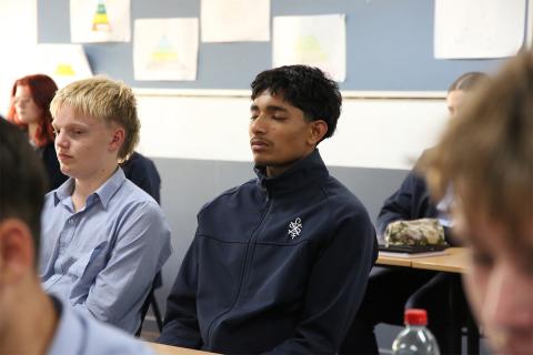 Two students in a class with their eyes closed